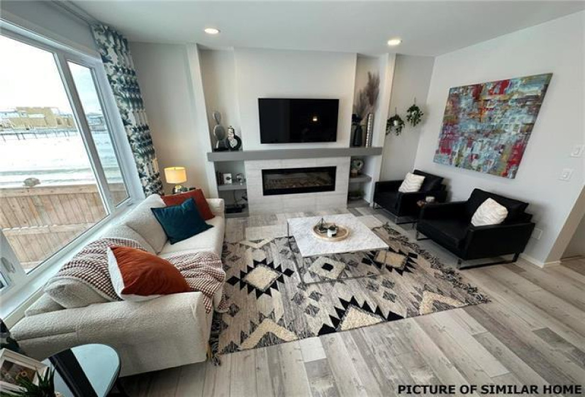 Living rm with linear electric FP and entertainment unit.