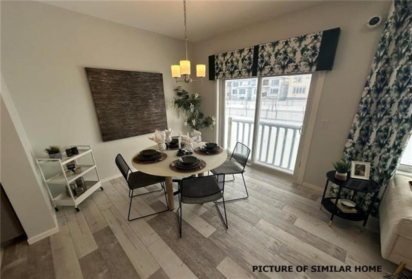 Eating area with sliding patio doors to the the future deck. Plank flooring.
