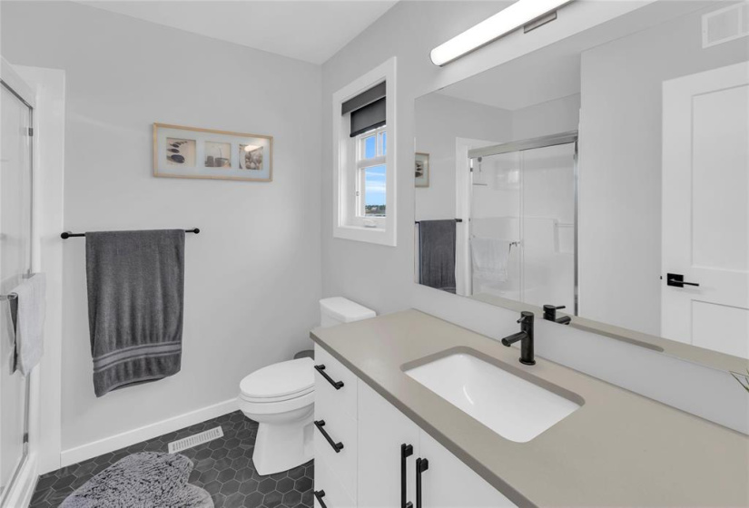 Primary Bdrm w/3 pce Enste w/4 ft walk-in shower, window for natural light & quartz/caesarstone counter with undermount sink.