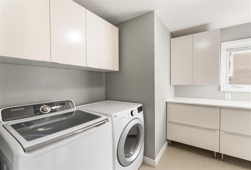 Wonderful spacious laundry room upstairs with extra cupboards added to maximize storage and space