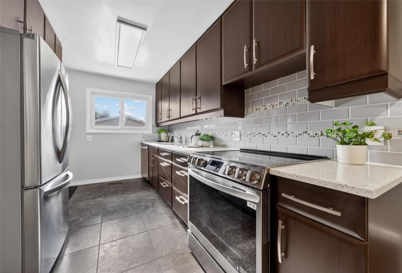 Stainless steel appliances & glass tile backsplash.
