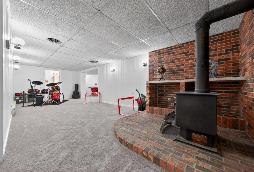 Large rec room in basement with ornamental stove.