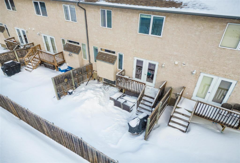 Back yard with privacy fences, small deck, patio area and flower garden