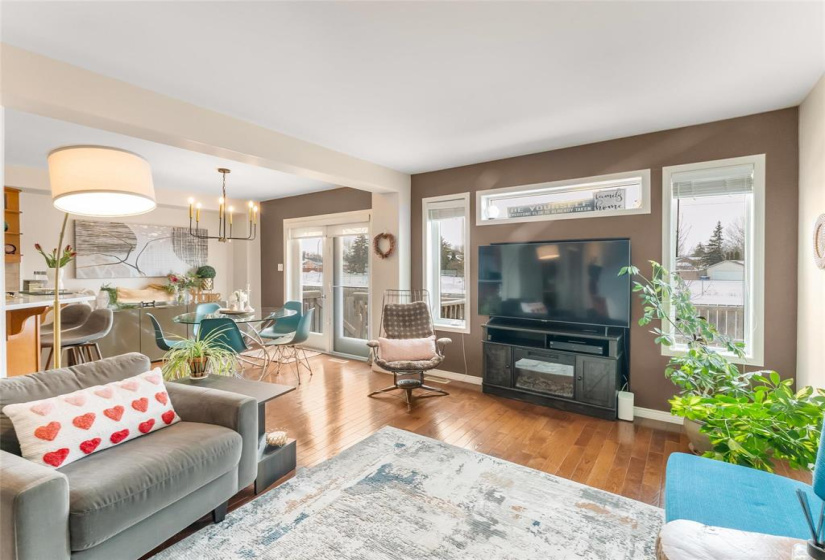 Living room to dining room view. Garden doors to deck and West facing back yard. Amazing views of sun sets. Lots of warmth and sun in the back yard.