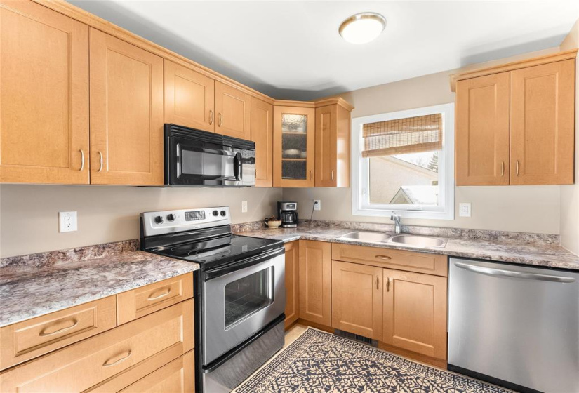 Updated kitchen with fridge, stove, dishwasher and built in microwave. Double sink and view to side yard.