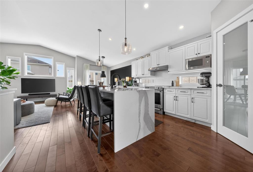 Open concept living room and kitchen with vaulted ceiling.