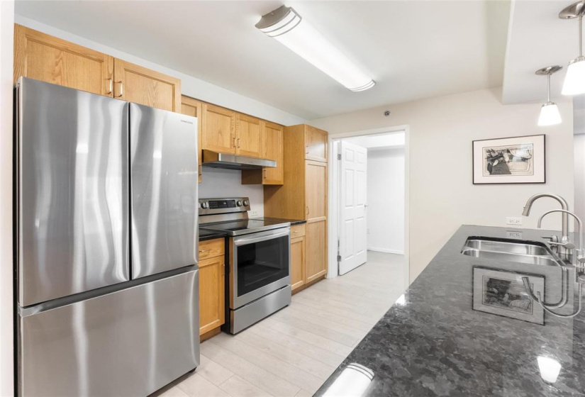 Kitchen with granite counters. Door is to laundry room and central vac canister