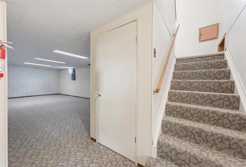 Spacious back stair landing to backyard also leads downstairs to basement rec room.