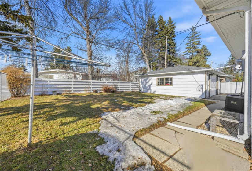 Spacious backyard and view of single detached garage.