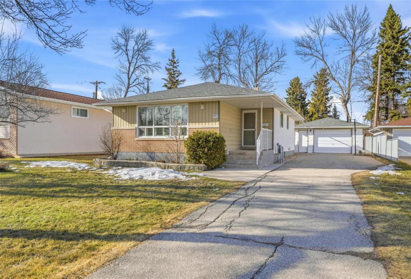 Extended driveway leads to single detached garage.