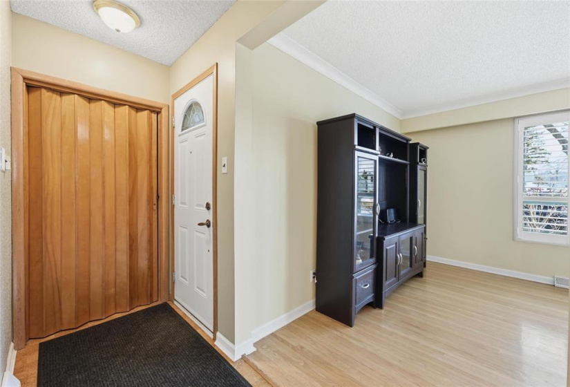 Spacious front entrance with large coat closet featuring wooden accordion door.