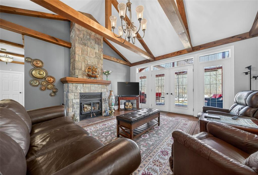 Living room with 13' vaulted ceiling wood-burning fireplace, & patio doors to massive covered patio.