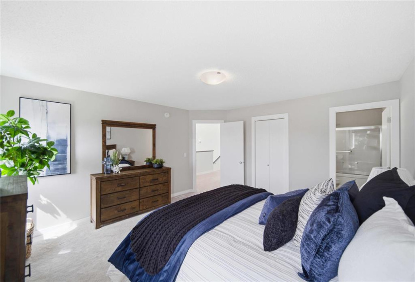 Secluded primary wing featuring a spacious 4-piece ensuite with quartz finishes, an expansive walk-in closet and scenic backyard views.