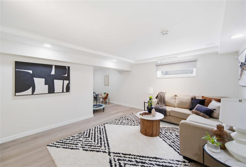 Expansive lower-level retreat featuring a massive recreation room with play area, 4-piece bath, and two additional bedrooms - one currently utilized as a home gym