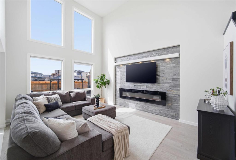 Stunning 18-foot ceilings accentuating a designer stone feature wall with an integrated electric fireplace