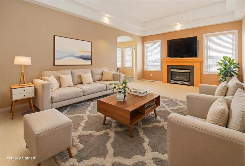 Spacious great room with tray ceiling and cozy gas fire place