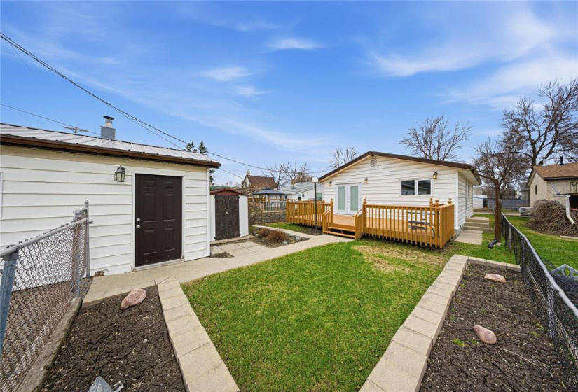 Yard with plant beds, storage shed, garage
