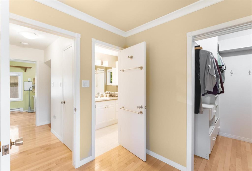 Primary walk-in closet with closet organizers. Door to bathroom (cheater ensuite)