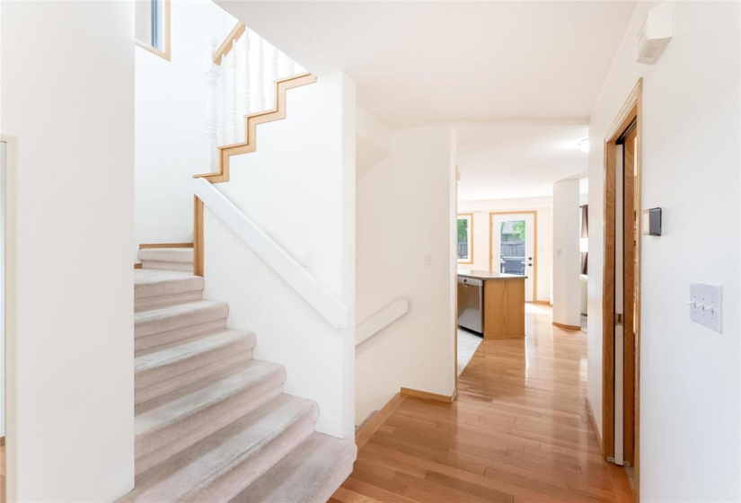 Staircase to upper level and view to kitchen