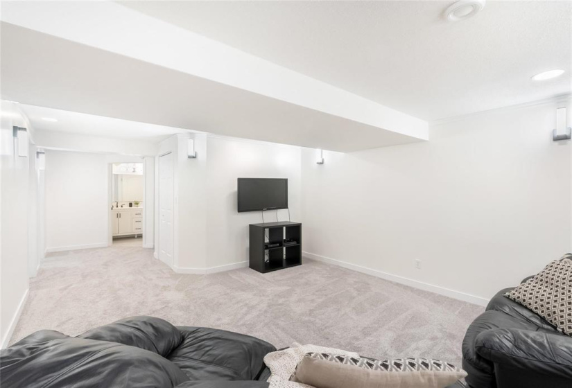 Rec room. Under the stairs is the sump pump.  Bathroom straight ahead