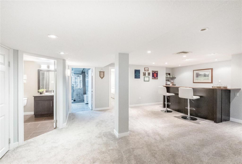 Rec room and view of dry bar, office, bathroom and utility room