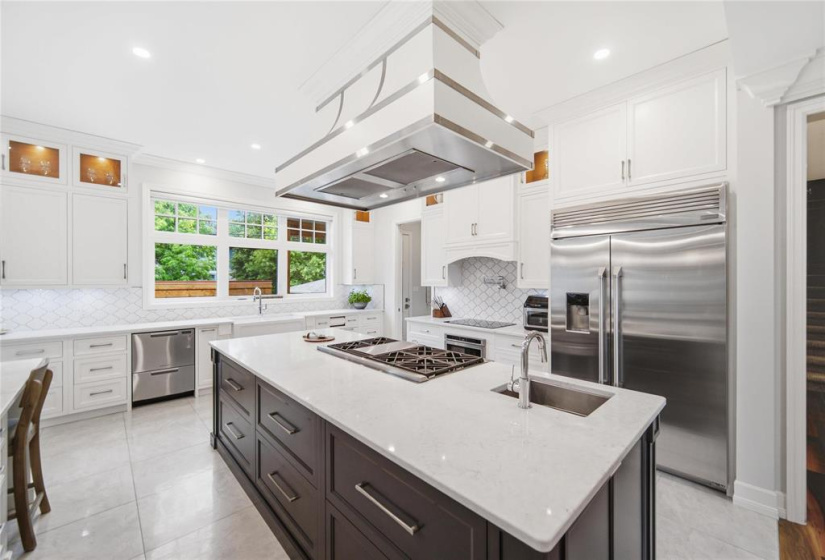 Striking island range hood over the Monogram gas range, a chef's delight