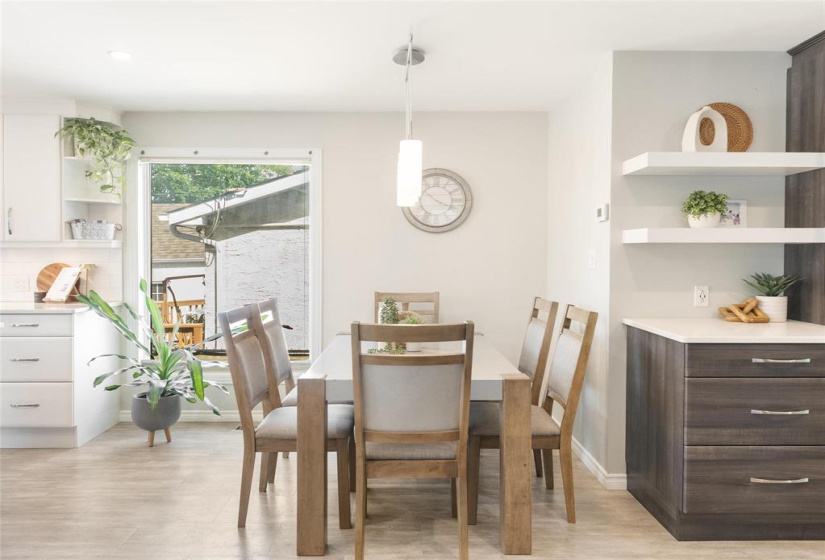 Dining area with large bright window. The cabinets beside would make a perfect bar, entertainment space