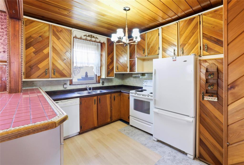 Penisula Kit with B/I Dshwr, Fridge & Stove. Wdw looking out to the back yard.
